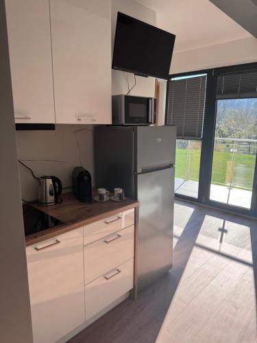 a kitchen with a refrigerator and a microwave at Apartament w Dolinie Sanu Lesko in Lesko