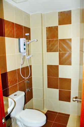 ein Badezimmer mit Toilette und Dusche in der Unterkunft Coron Visitors Hotel in Coron