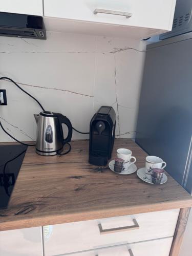two cups of coffee sitting on a wooden table at Apartament w Dolinie Sanu Lesko in Lesko