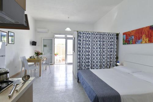 a hotel room with a bed and a dining room at Residence Baia D'Oro in Torre Mozza
