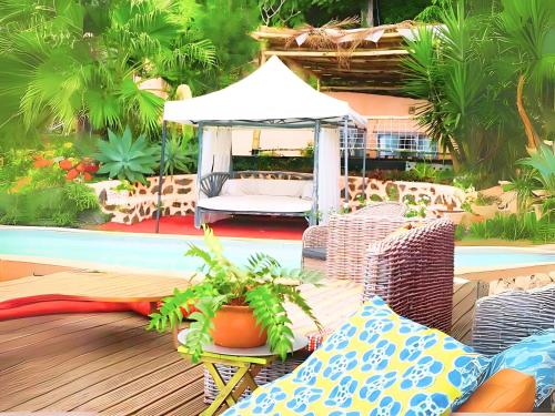 a painting of a patio with a gazebo at Bungalow lumineux à Saint Leu proche de la mer avec piscine partagée in Saint-Leu