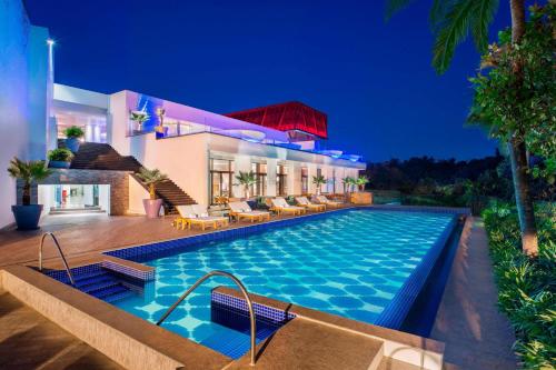 a villa with a swimming pool at night at W Goa in Vagator