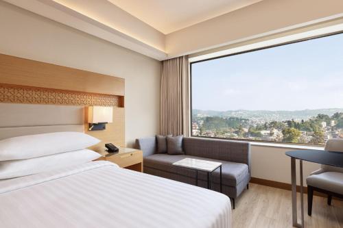 a hotel room with a bed and a window at Courtyard by Marriott Shillong in Shillong