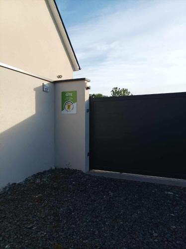 un garage avec une porte noire à côté d'un bâtiment dans l'établissement La vie est belle, à Ryes