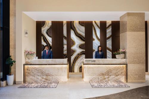 two women standing in front of a lobby at Courtyard by Marriott Shillong in Shillong