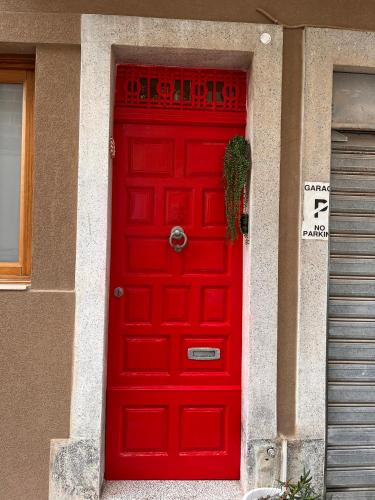 a red door of a house with a sign on it at Cozy, modern and welcoming in Il-Ħamra