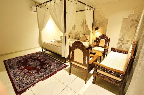 a bedroom with a bed and two chairs and a mirror at RiverView Tent Resort in Kevadia