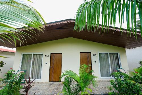 a small house with wooden doors in a garden at RiverView Tent Resort in Kevadia
