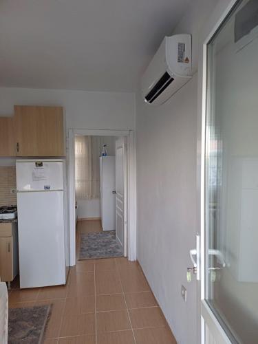 a kitchen with a white refrigerator and a hallway at Elite Apart Pansiyon in Gokceada Town