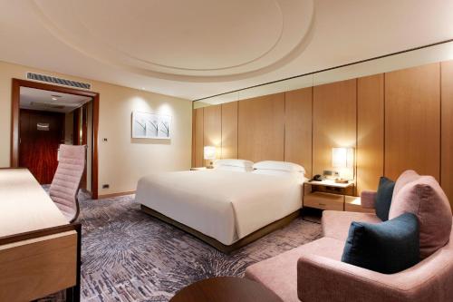 a hotel room with a bed and two chairs at Sheraton Grand Taipei Hotel in Taipei