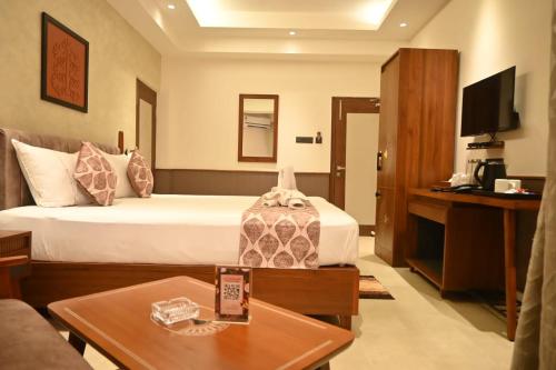 a hotel room with a bed and a table at Hotel Sonar Bangla Tarapith in Tarapith