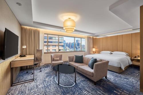 a hotel room with a bed and a television at Sheraton Grand Taipei Hotel in Taipei