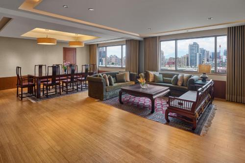 a living room with a couch and a table at Sheraton Grand Taipei Hotel in Taipei