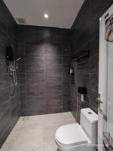 a bathroom with a toilet and a glass shower at Austin Melaka in Kampong Sungai Putat