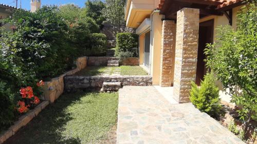 a garden with a stone walkway next to a house at Studio Xanthippe in Kalamos