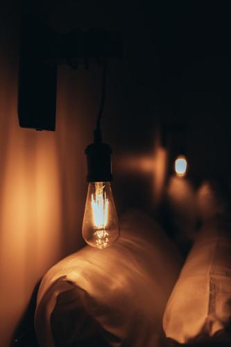 a light bulb hanging on a bed in a dark room at The Kings Head, Usk in Usk
