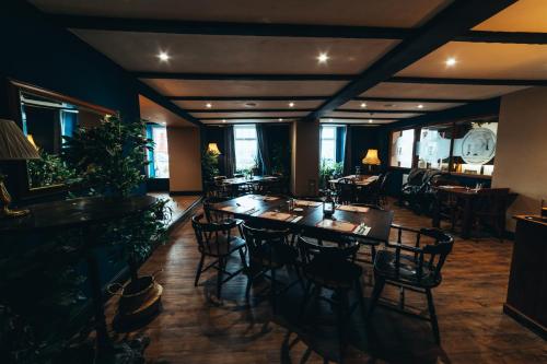 a restaurant with tables and chairs and a clock on the wall at The Kings Head, Usk in Usk