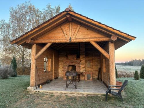 a log cabin with a fireplace in the yard at Villa Vesta in Dolnāja
