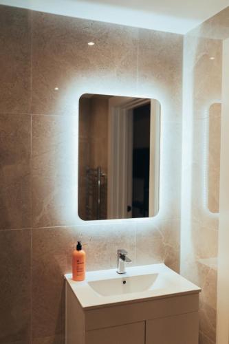 a bathroom with a sink and a mirror at The Kings Head, Usk in Usk