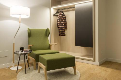 a living room with a green chair and a tv at ARTIEM Madrid in Madrid