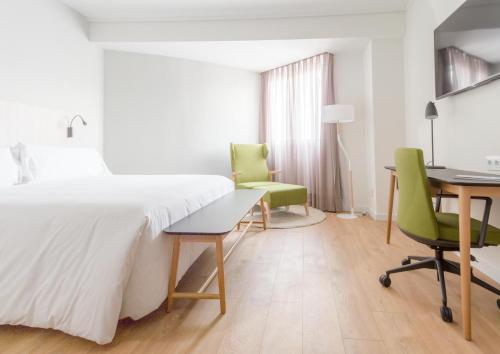 a bedroom with a bed and a desk and chairs at ARTIEM Madrid in Madrid