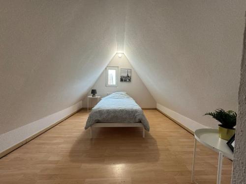 a room with a bed in the middle of a attic at Tranquillité in Rountzenheim