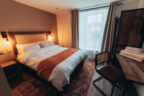 a bedroom with a large bed and a window at The Kings Head, Usk in Usk