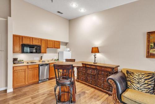 a kitchen with a counter and a chair and a table at Grand Wood Suites - 3rd Floor Front Side Penthouse Suite 303 in Nashville