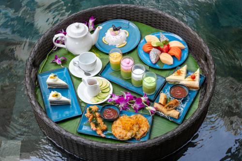 a tray of food on a table in the water at Bayon Modern Residence in Siem Reap