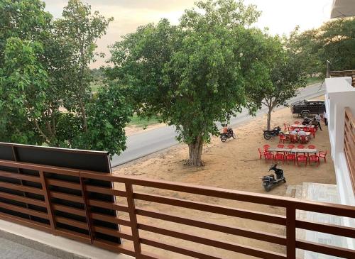 a balcony with a view of a park with tables and trees at Shekhawat and Saini restaurant in Gogameri