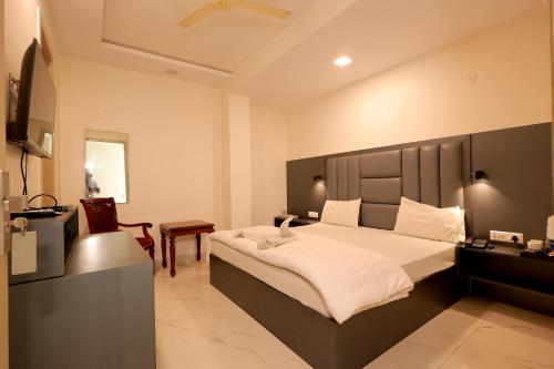 a bedroom with a large bed and a desk at Hotel Palace inn Agra in Tājganj