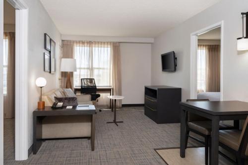 a hotel room with a desk and a living room at Residence Inn Salt Lake City Airport in Salt Lake City