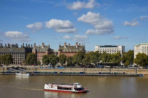 a boat traveling down a river in a city at London Marriott Hotel County Hall in London