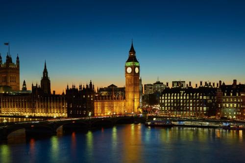 a city with a clock tower and big ben at night at London Marriott Hotel County Hall in London