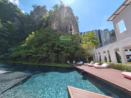 a swimming pool with lounge chairs and a building at The Cove Premium Suites 7-13pax by IWH Suites in Ipoh