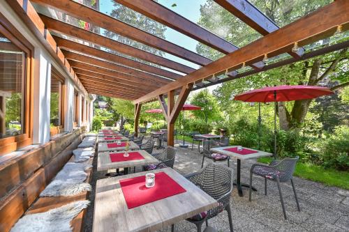 an outdoor patio with tables and chairs with red napkins at Hotel Ruchti - Zeit für mich in Füssen