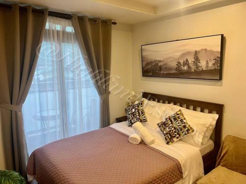 a bedroom with a bed and a window at 'Highland Escape' Condo Studio Unit in Baguio