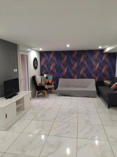 un salon avec un canapé et une télévision dans l'établissement Appartement au calme, à Chantepie