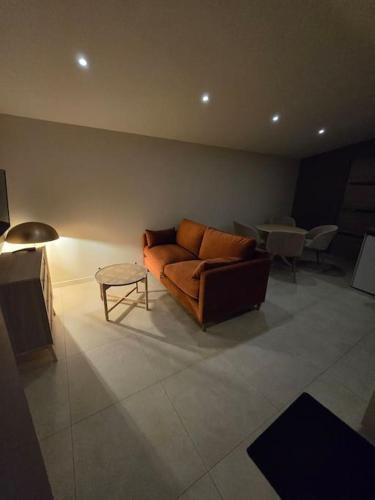 a living room with a couch and a table at À L'ombre Du Pêcher in Pleurtuit