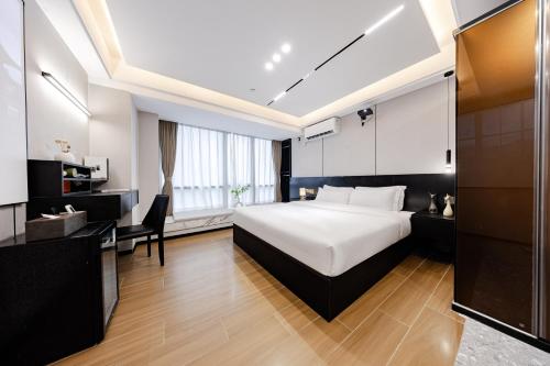 a bedroom with a bed and a desk and a chair at Yufei high-altitude night view Huge-Screen Audiovisual Hotel-Guangzhou Tower Zhujiang New Town Sports West Road Branch in Guangzhou