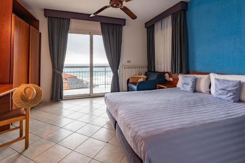 Un dormitorio con una cama grande y una sala de estar. en Hotel Lungomare, en Andora