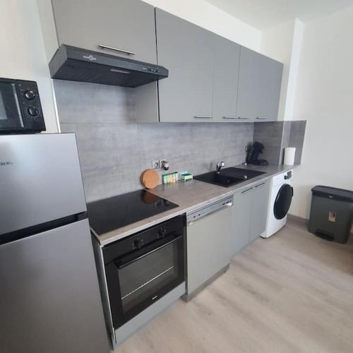 une petite cuisine avec un évier et un réfrigérateur dans l'établissement Appartement Brest Kerinou avec box internet, à Brest