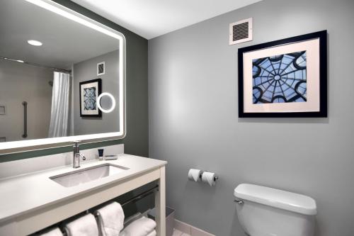 a bathroom with a sink and a mirror and a toilet at Four Points by Sheraton York in York
