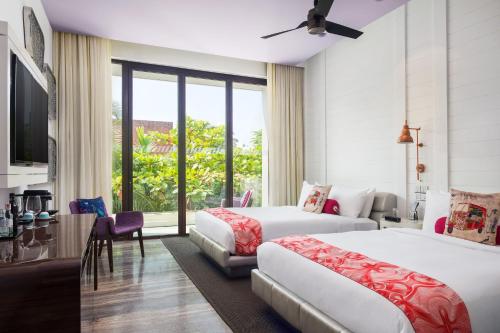 a hotel room with two beds and a window at W Goa in Vagator