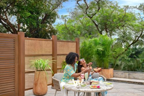 two women sitting at a table on a patio at W Goa in Vagator