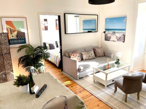 un salon avec un canapé et une table dans l'établissement En face de l'hôtel Normandy - Appartement dernier étage, à Deauville