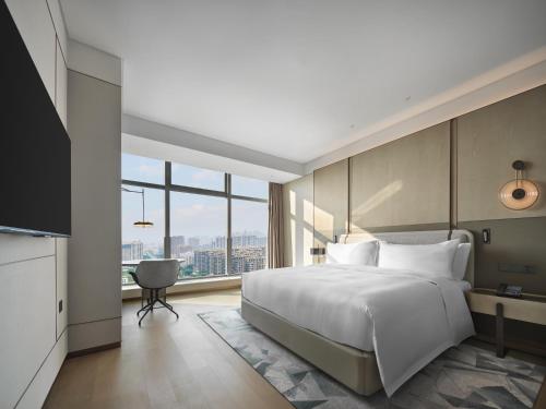a bedroom with a large bed and a large window at Doubletree By Hilton Rugao in Rugao