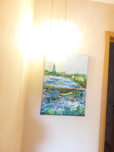 a painting hanging on a wall next to a window at La grange aux dîmes in Walcourt