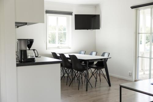 a kitchen and dining room with a table and chairs at Halens Camping och Stugby in Olofström