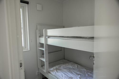 a white bunk bed in a room with a window at Halens Camping och Stugby in Olofström